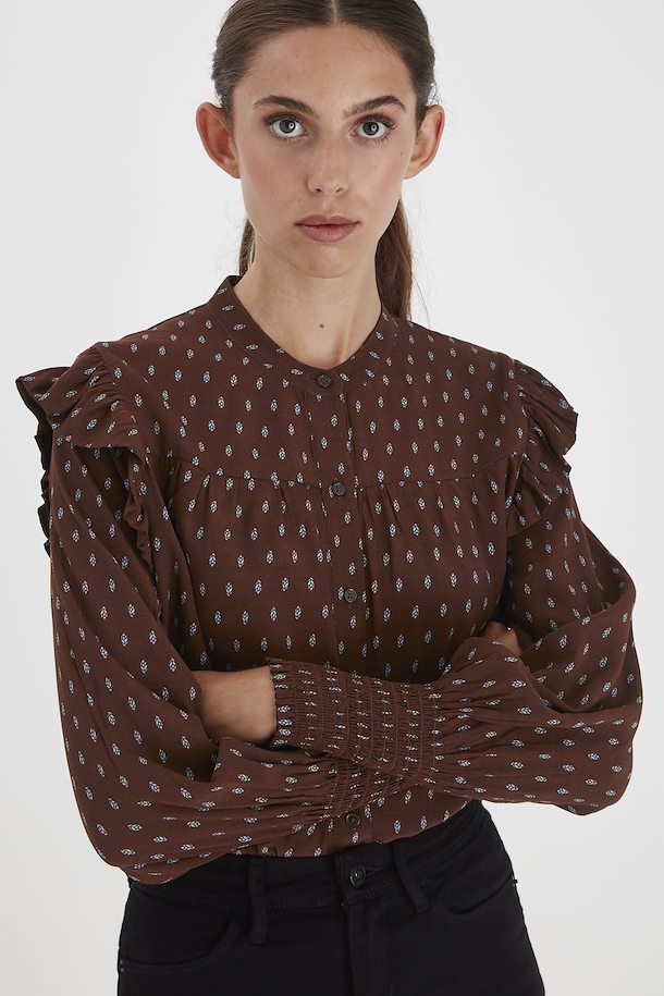 Front view of model wearing ICHI Carina long sleeve printed blouse. Cappuccino brown with light blue print. Frilled detail at shoulders, shirred cuffs. 